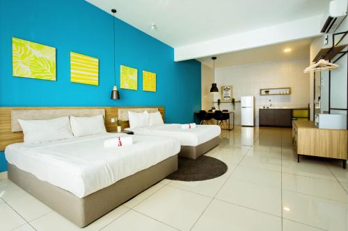 1 dormitorio con 2 camas y pared azul en Da Men Sunway Subang By ODY Suites, en Subang Jaya