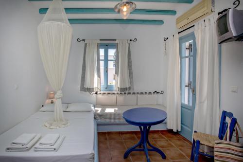 a room with a bed and a blue table at Ethelio in Agios Ioannis Tinos