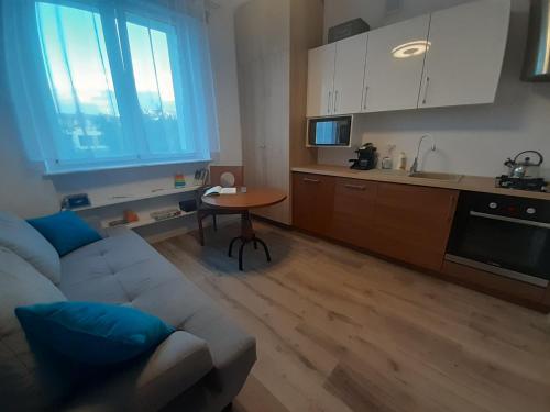 a living room with a white couch and a kitchen at Gdynia99 in Gdynia
