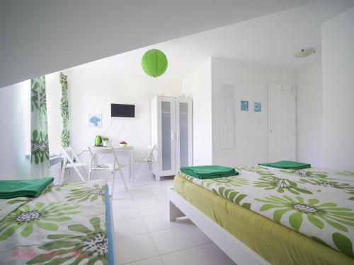 a white room with two beds and a dining room at Villa del Mar in Łeba