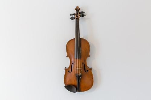 um violino pendurado numa parede em Ansager Hotel og Hytteby em Ansager