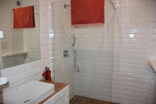 a white bathroom with a sink and a shower at Klara - Harmonia Oliwska in Gdańsk