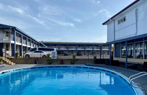 a large swimming pool in front of a building at R Nite Star Inn and Suites -Home of the Cowboys & Rangers in Arlington