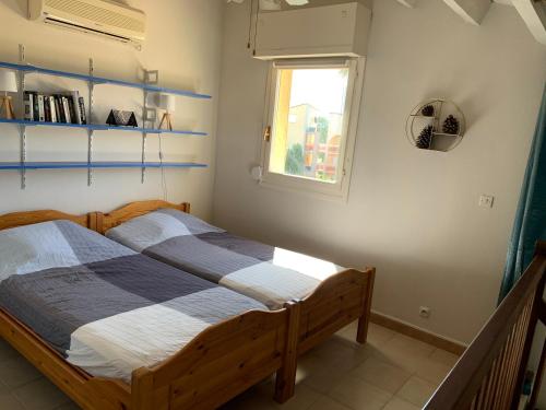 a bedroom with a wooden bed with a window at Duplex rénové les pieds dans l'eau in Calvi