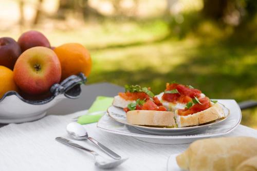 a table with two plates of food and a bowl of fruit at B&B Vallecupa in Farnese