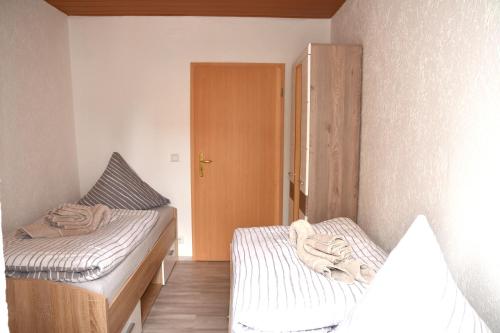 ダイデスハイムにあるFeWo 2 - Deidesheimのベッド2台とクローゼットが備わる小さな客室です。