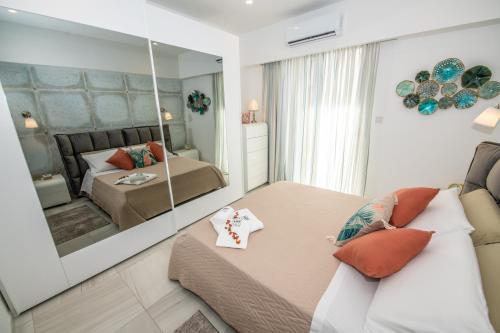 a bedroom with a mirror and a bed and a couch at Artist Terrace Apartments in Mellieħa