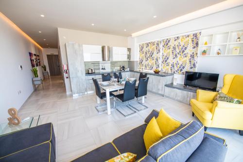 a living room with yellow furniture and a dining room at Artist Terrace Apartments in Mellieħa