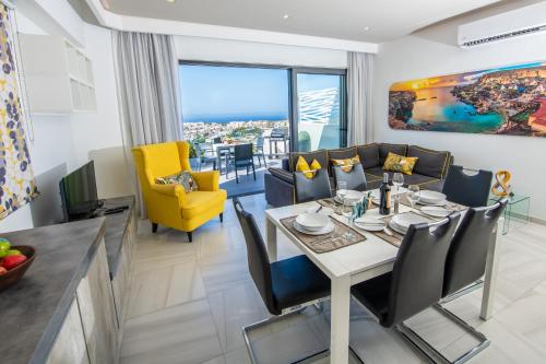 ein Esszimmer und ein Wohnzimmer mit einem Tisch und Stühlen in der Unterkunft Artist Terrace Apartments in Mellieħa