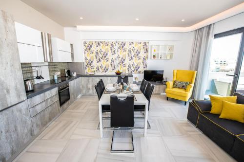 a kitchen and living room with a table and chairs at Artist Terrace Apartments in Mellieħa