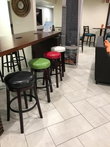 a bar with four stools in a room at Baymont by Wyndham Chicago/Alsip in Alsip