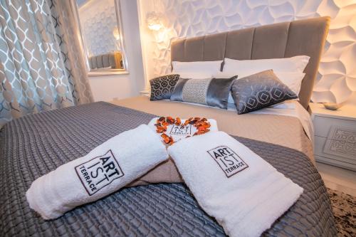 a bedroom with a bed with two white towels at Artist Terrace Apartments in Mellieħa