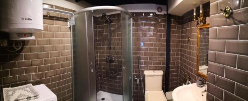 a bathroom with a toilet and a glass shower at Затишні апартаменти, Дерибасівська in Odesa