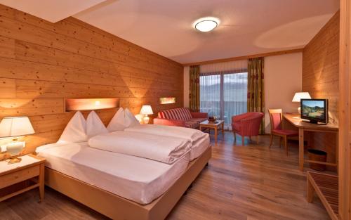 ヴィッランドロにあるAktiv & Relax Hotel Hubertusのベッドとテレビが備わるホテルルームです。