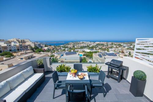 d'une terrasse avec une table et des chaises sur un balcon. dans l'établissement Artist Terrace Apartments, à Mellieħa