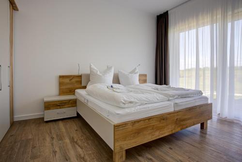 a large bed in a room with a large window at Villa Zeitlos in Börgerende-Rethwisch