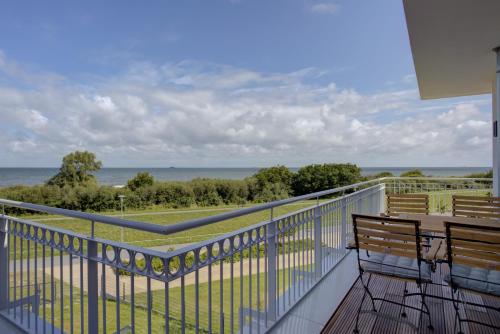 a balcony with a bench and a view of the ocean at Villa Zeitlos in Börgerende-Rethwisch