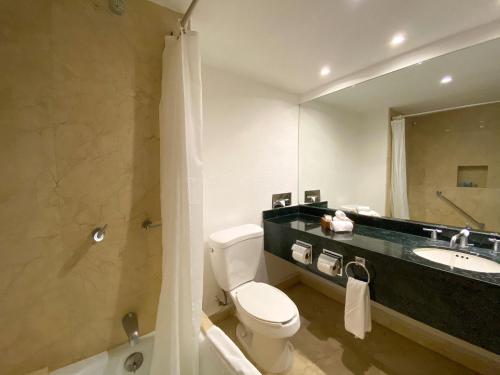 bagno con servizi igienici, lavandino e specchio di Flamingo Cancun All Inclusive a Cancún