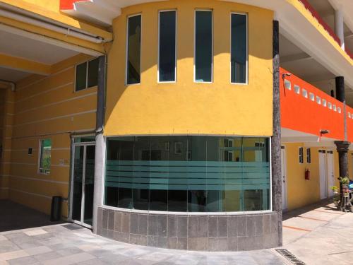 a yellow building with black windows on the side of it at HOTEL LAS FUENTES in Tepotzotlán