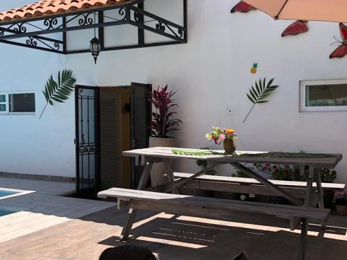 a picnic table with a bench and an umbrella at HOTEL LAS FUENTES in Tepotzotlán