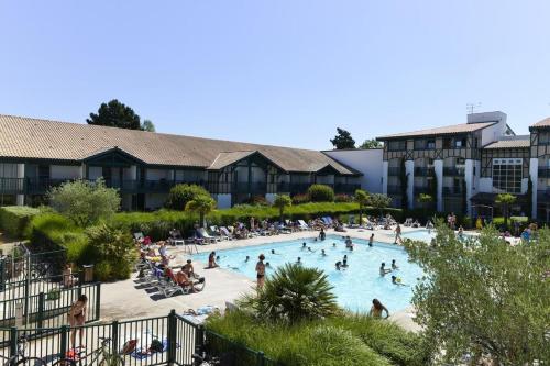 un groupe de personnes dans une piscine d'un complexe hôtelier dans l'établissement PIERRE ET VACANCES STUDIO, à Moliets-et-Maa