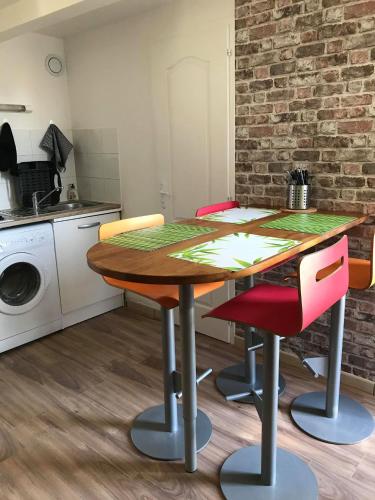 une cuisine avec une table et des chaises dans une pièce dans l'établissement L'échoppe Rochelaise, à La Rochelle