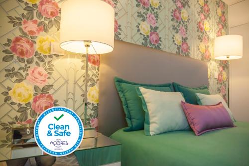 a room with a bed with a lamp and flowers at Casa do Ácer in São Vicente Ferreira