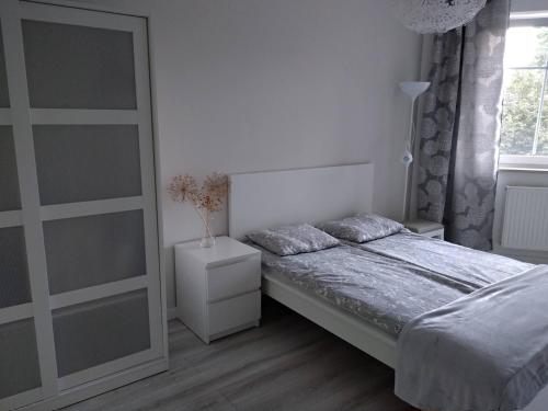 biała sypialnia z łóżkiem i oknem w obiekcie RiC Apart - Apartament Mostowa, centrum Poznań - parking - klimatyzacja w Poznaniu