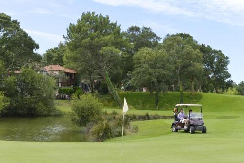 a group of people riding a golf cart on a golf course at PIERRE ET VACANCES STUDIO in Moliets-et-Maa