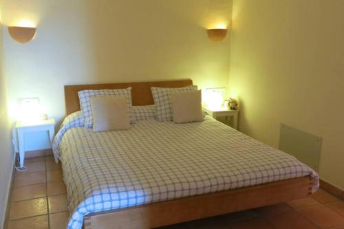 a bedroom with a bed with a checkered blanket and pillows at Apartamento en el Puerto de Sóller con gran terraza privada y vistas al mar. Piscina comunitaria. Localizado en un zona tranquila y muy soleada. Wifi gratis disponible. Parking. in Port de Soller