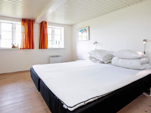 a bedroom with a large white bed with pillows at Holiday home Rudkøbing XI in Rudkøbing