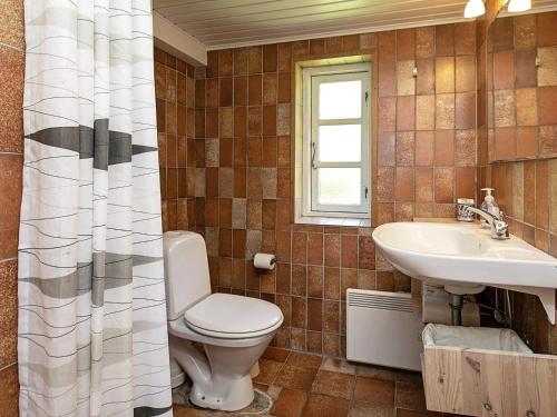 a bathroom with a toilet and a sink at Holiday home Rudkøbing XI in Rudkøbing