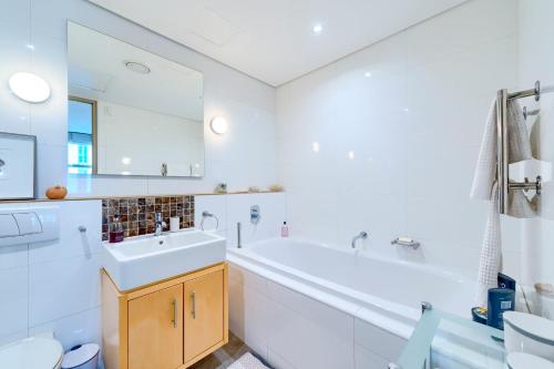 une salle de bain blanche avec une baignoire et un lavabo dans l'établissement #505 Cartwright - Old World Charm, au Cap