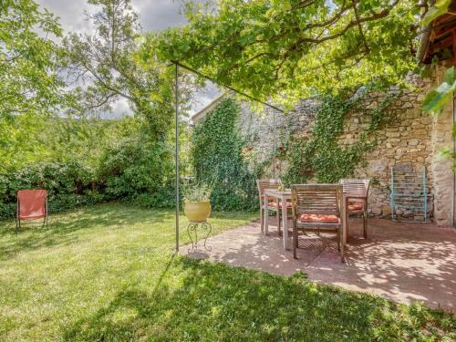 een patio met een tafel en stoelen in een tuin bij Cosy holiday home with garden in Ponet-et-Saint-Auban