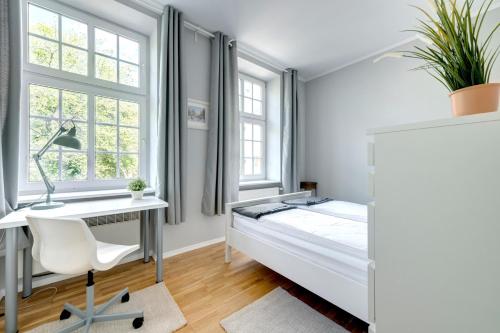 Schlafzimmer mit einem Bett, einem Schreibtisch und Fenstern in der Unterkunft Mariacka Apartment Old Town Gdansk in Danzig