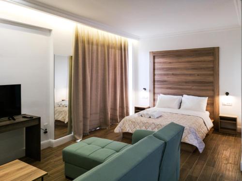 pokój hotelowy z łóżkiem i kanapą w obiekcie Laura maisons w Kalamácie