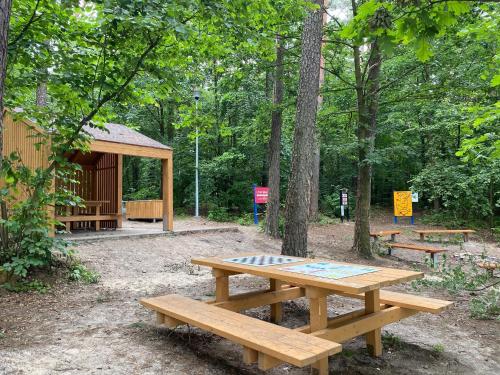 a picnic table and bench in front of a cabin at Family & Business Sauna Apartments No2 Leśny nad Zalewem Cedzyna - 2 Bedroom with Private Sauna, Bath with Hydromassage, Terrace, Parking, Catering Options in Kielce