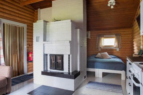 Petäjävesiにあるレムティラ コテージズの家の中に暖炉付きのベッドルーム