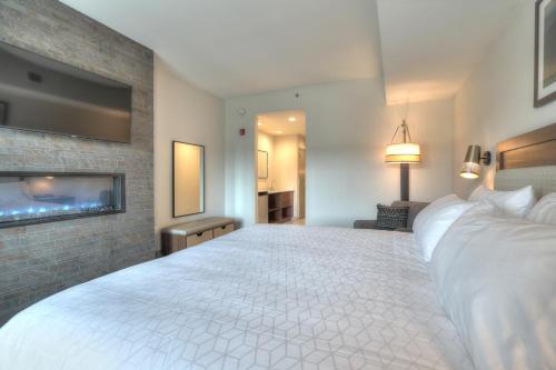 a hotel room with a large bed and a flat screen tv at Holiday Inn & Suites Pigeon Forge Convention Center by IHG in Pigeon Forge