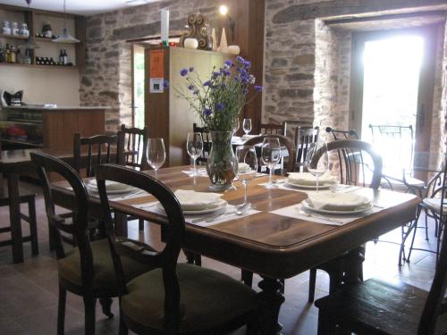 een eetkamer met een tafel met stoelen en bloemen erop bij Casa da Sapeira in Santa Eulalia de Oscos