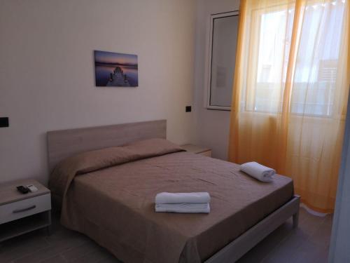 a bedroom with a bed with two towels on it at Appartamento a San Vito lo capo in San Vito lo Capo