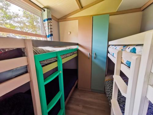 a room with two bunk beds and a window at Au Bonheur Nomade in Livry