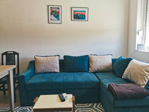 a living room with a blue couch and a table at Cozy Corner Apartments - Free parking & Wi-fi in Ćuprija
