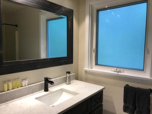 a bathroom with a sink and a large mirror at Canadian Rockies Inn - Adults only in Field