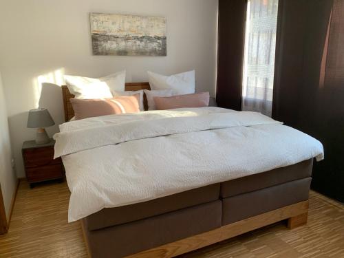 ein Bett mit weißer Bettwäsche und Kissen in einem Schlafzimmer in der Unterkunft Luxuriöse Stadtwohnungen in Königstein in Königstein an der Elbe