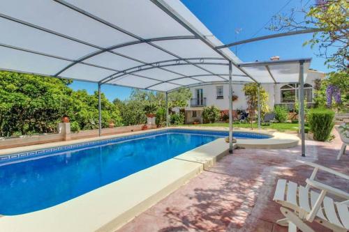 a swimming pool with a pergola next to a house at Villa Paradise Private pool and garden in a natural park for 9 in Aduanas