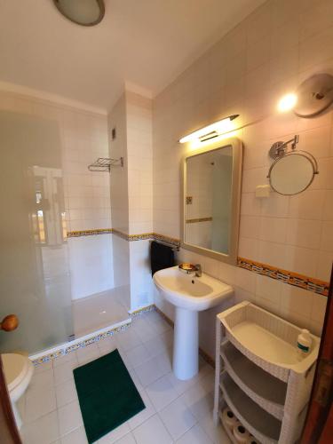 a bathroom with a sink and a tub and a mirror at Big Fish 1 - Charming Beach Apartment in Praia de Mira