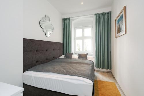 a bedroom with a large bed with green curtains at 4 Personen Altbau nahe Kurfürstendamm - Macbeth in Berlin