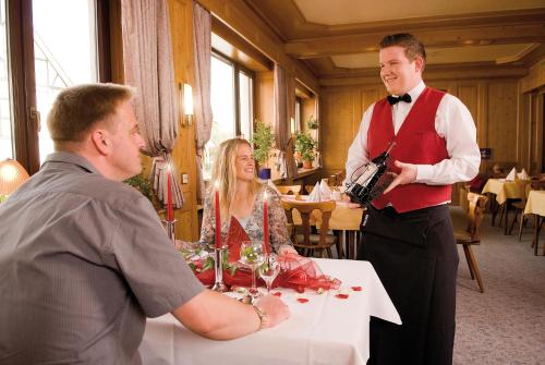 a man is holding a gun while a man is sitting at a table at Hotel Haus Wiesengrund in Hallenberg