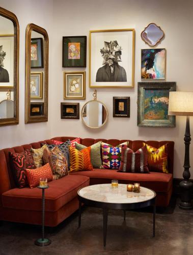 a living room with a red couch and a table at The Plaza Hotel Pioneer Park in El Paso
